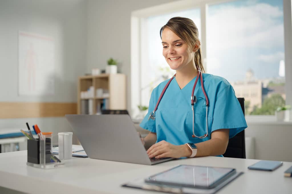Nurse smiling while on her laptop