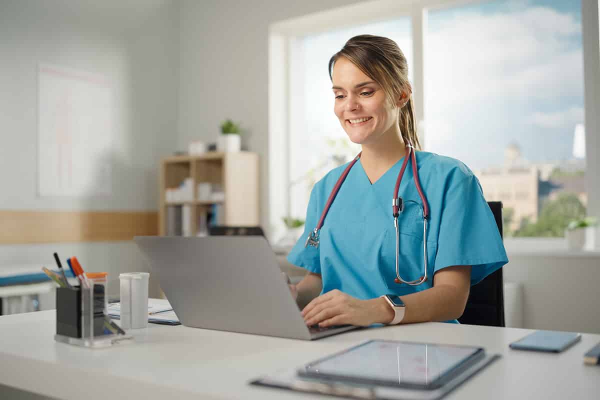 Nurse smiling while on her laptop
