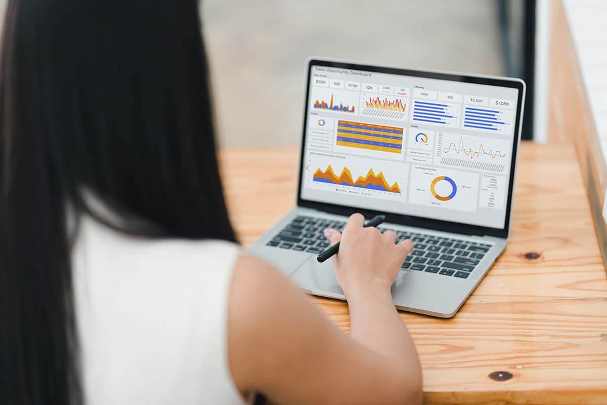 Businesswoman or an accountant team are analyzing data charts, graphs, and a dashboard on a laptop screen in order to prepare a statistical report