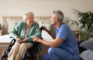 Caregiver doing regular check-up of senior woman in her home.