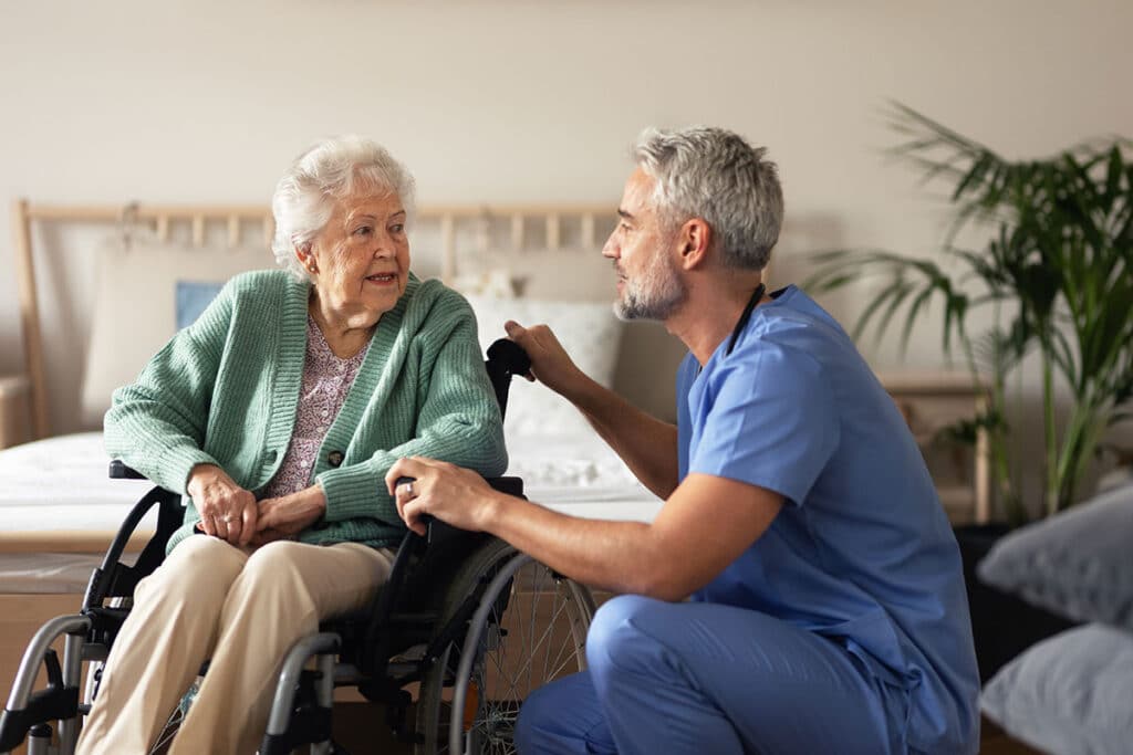 Caregiver doing regular check-up of senior woman in her home.