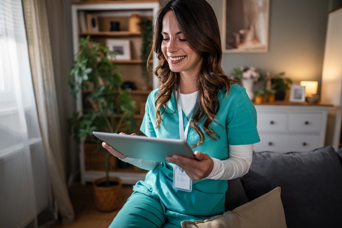 home-health-aide-using-a-tablet-and-smiling